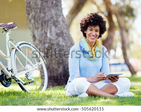 Young woman using tablet in the park.