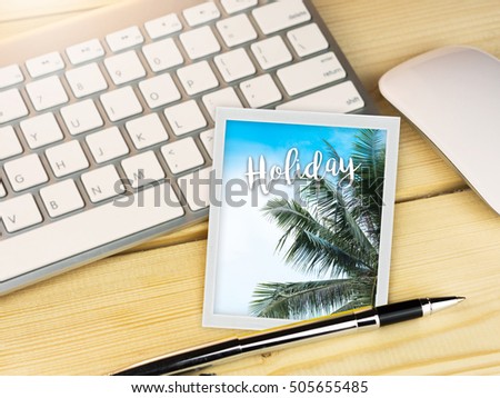Holiday text on coconut tree picture on work table; work and holiday concept