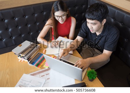 Profile of a happy couple searching information on line together connected in a laptop inside a coffee shop with an exterior background.