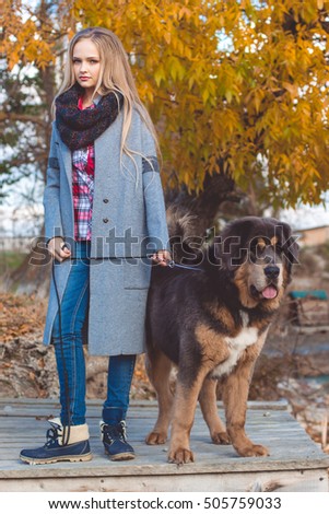 Pretty blonde girl with mastiff on the nature