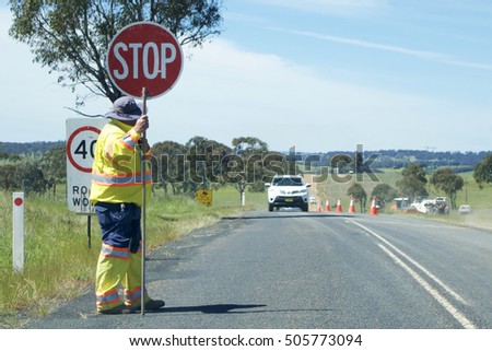 Road Stop sign being held by a worker on a country road in Australia.