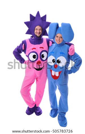 Portrait in full growth, isolated: kids animators in full body plushy costumes with painted smiling eyes and mouth, in a hat with ears and needle - man as hedgehog and lady as bunny fooling around