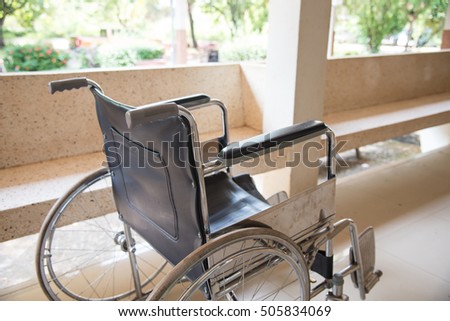 Empty wheelchair parked in hospital with selective focus.