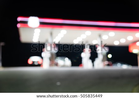 Blurred image of gas station with car refueling at night. Defocused, out of focus gas station and convenience store in twilight. Abstract blur petrol station background with copy space.