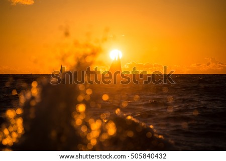 colorful orange sunrise over the lake in summer with small boat