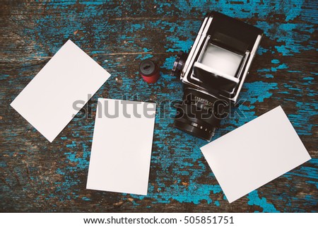 Blank moke up for design of photographer. Film photo camera with print photo. Medium format photo camera and photo on wood background.