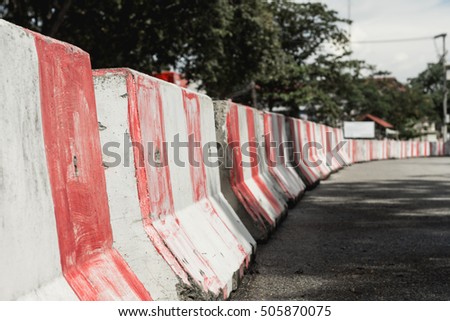 red and white concrete barriers blocking the road