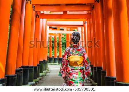 Women in kimono stand at Red Torii gates in Fushimi Inari shrine, one of famous landmarks in Kyoto, Japan Royalty-Free Stock Photo #505900501