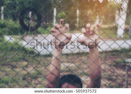 Two hand with metal fence, feeling no freedom