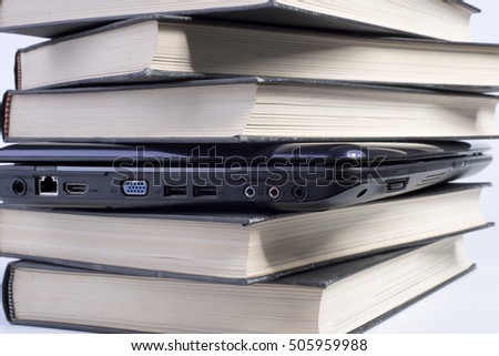 Past and present. stack of books with a laptop in the middle