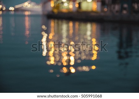 Boat blurred reflections over the sea - Dusk skyline bokeh over the sea - Pier at night