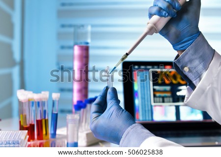 scientist holding tube and working with laptop at genetic lab / hands of engineer genetic working in laboratory Royalty-Free Stock Photo #506025838