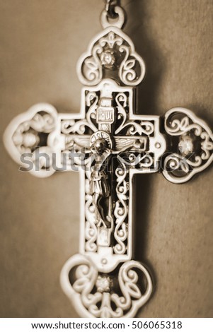 the cross hanging on the neck of a man