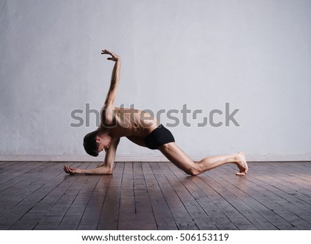 Athletic ballet dancer in a perfect shape performing dramatic dance.
