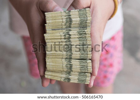 
Hand giving Thai banknotes, were tied with a rubber band.