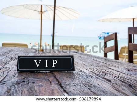 VIP banner on restaurant table, beach background Royalty-Free Stock Photo #506179894