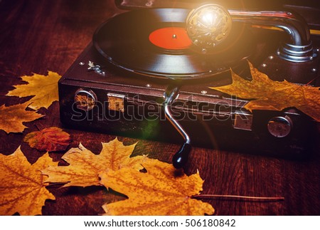 An old dusty gramophone playing a vinyl record at autumn time