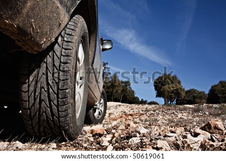 SUV climbing a rocky mountain under a deep blue sky Royalty-Free Stock Photo #50619061