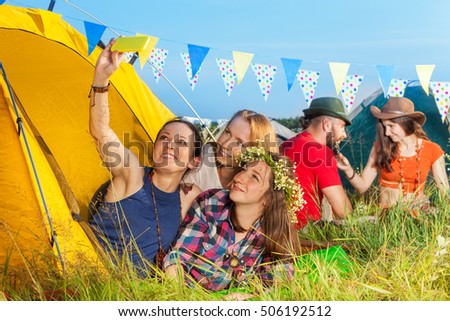 Three beautiful young woman in tent taking selfie