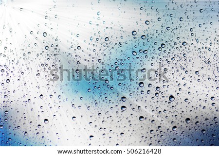 Abstract texture. Water drops on glass with sunny background 