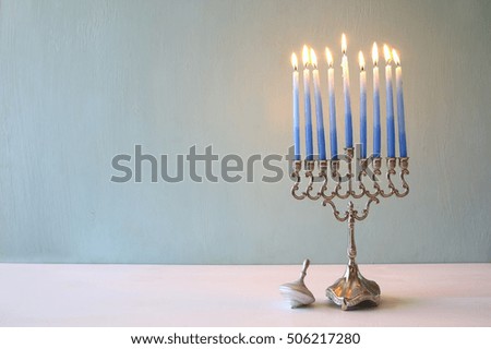 Image of jewish holiday Hanukkah with menorah (traditional Candelabra) and wooden dreidel (spinning top)