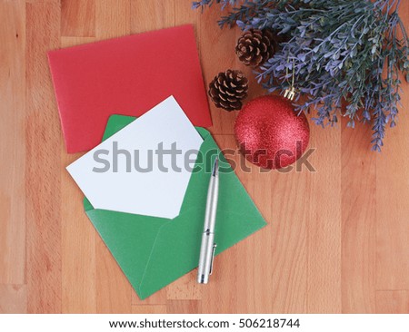 Empty Christmas greeting card with pen on wooden background 