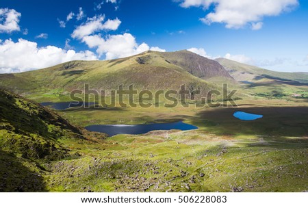 Brandon Mountain, the highest mountain on Ireland's Dignle Peninsula, stands above a deep glacial valley and lakes to the west of Conor Pass in County Kerry. Royalty-Free Stock Photo #506228083