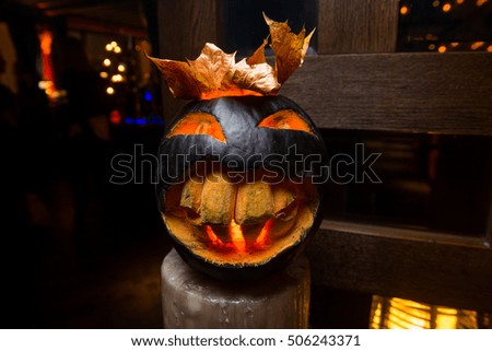Black Halloween pumpkin with big teeth and big smile in nightclub.Selective focus/Scary Halloween pumpkin with big smile