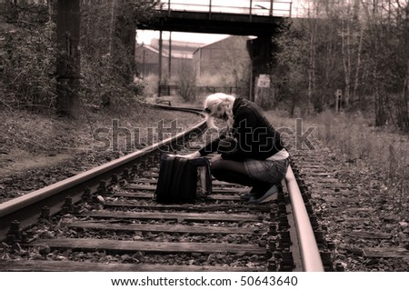 Girl sitting on railway