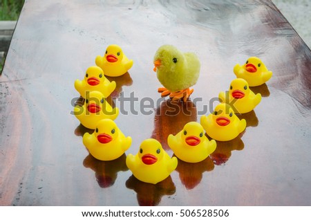 Duck and chick dolls, toys for children, on a table made of wood and background bokeh tree. (Select focus)
