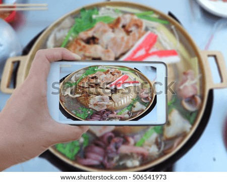 take a photo by mobile phone,image of pork on a hot plate.          