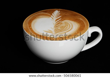 Soft focus photo of ceramic cup of cappuccino on black background.
