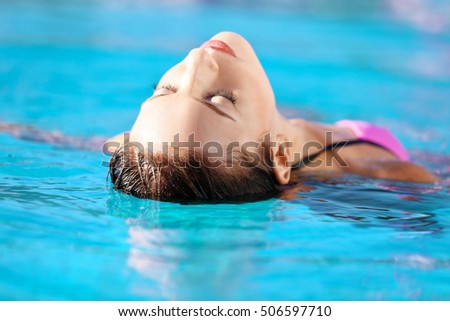 Portrait of beautiful young woman in swimming pool
