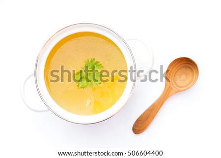 Bowl of chicken broth with wooden spoon isolated on white background