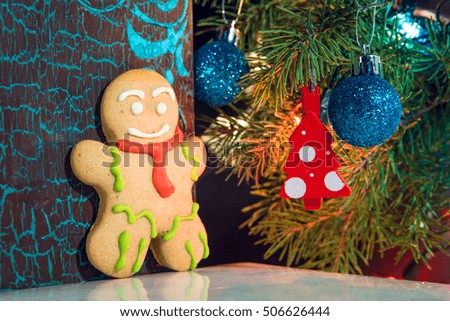 gingerbread man near Christmas tree with toys by garland, the concept of Christmas