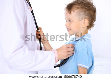 Happy little boy having fun while is being examine by doctor by stethoscope. Health care, insurance and help concept