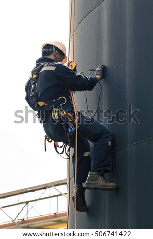 Male worker rope access  inspection of thickness storage tank industry.