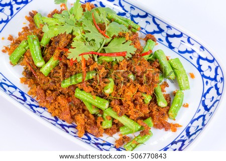 Stir fried crispy pork belly and red curry on white background