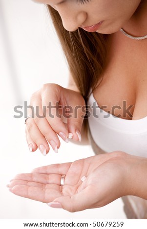 Closeup of young woman girl taking pills.