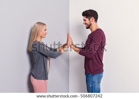 Together forever. Happy young loving couple is standing and joining their hands. They are looking at each other and smiling. Isolated