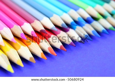 Colourful pencils in a row isolated on blue background