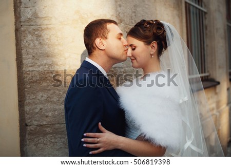 happy groom kisses his sweetheart