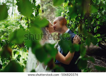 happy young couple kissing in green park