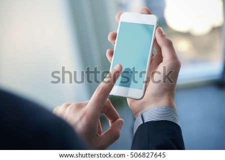 Mock up of a man holding device and touching screen. Clipping path Royalty-Free Stock Photo #506827645