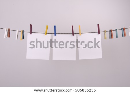  paper sheets hanging with pegs to a wire
