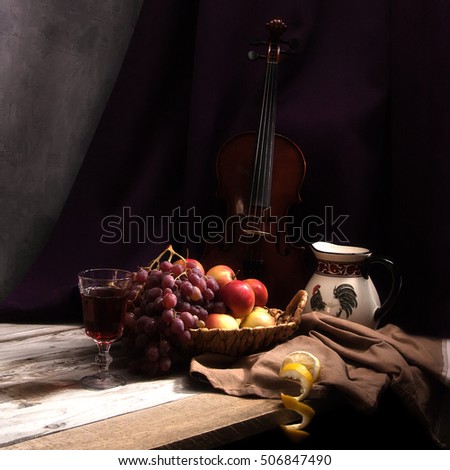 Still life with fruit in wicker basket with violin.