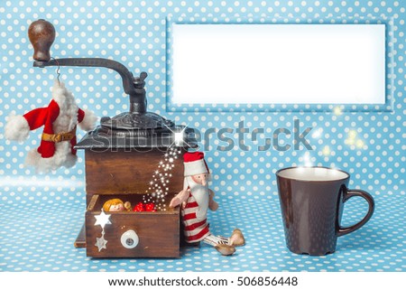 Christmas empty frame greeting card, vintage coffee grinder, cup of coffee Santa toy and Christmas decorations with empty picture frame to write message.