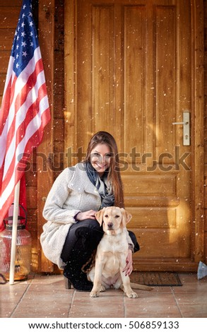 Girl with puppy in front of mountain wooden house 