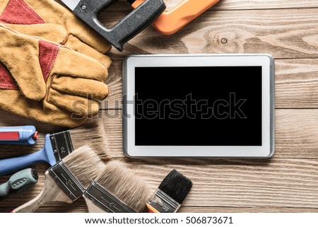 Variety of tools of builder and tablet pc on wooden texture table