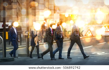 Business people walking in the City, blurred image with lights reflection. Business and modern life concept